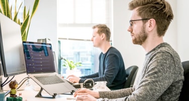 two persons working at their desks