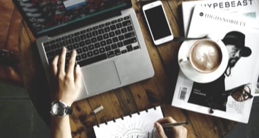 person working with laptop and notepad